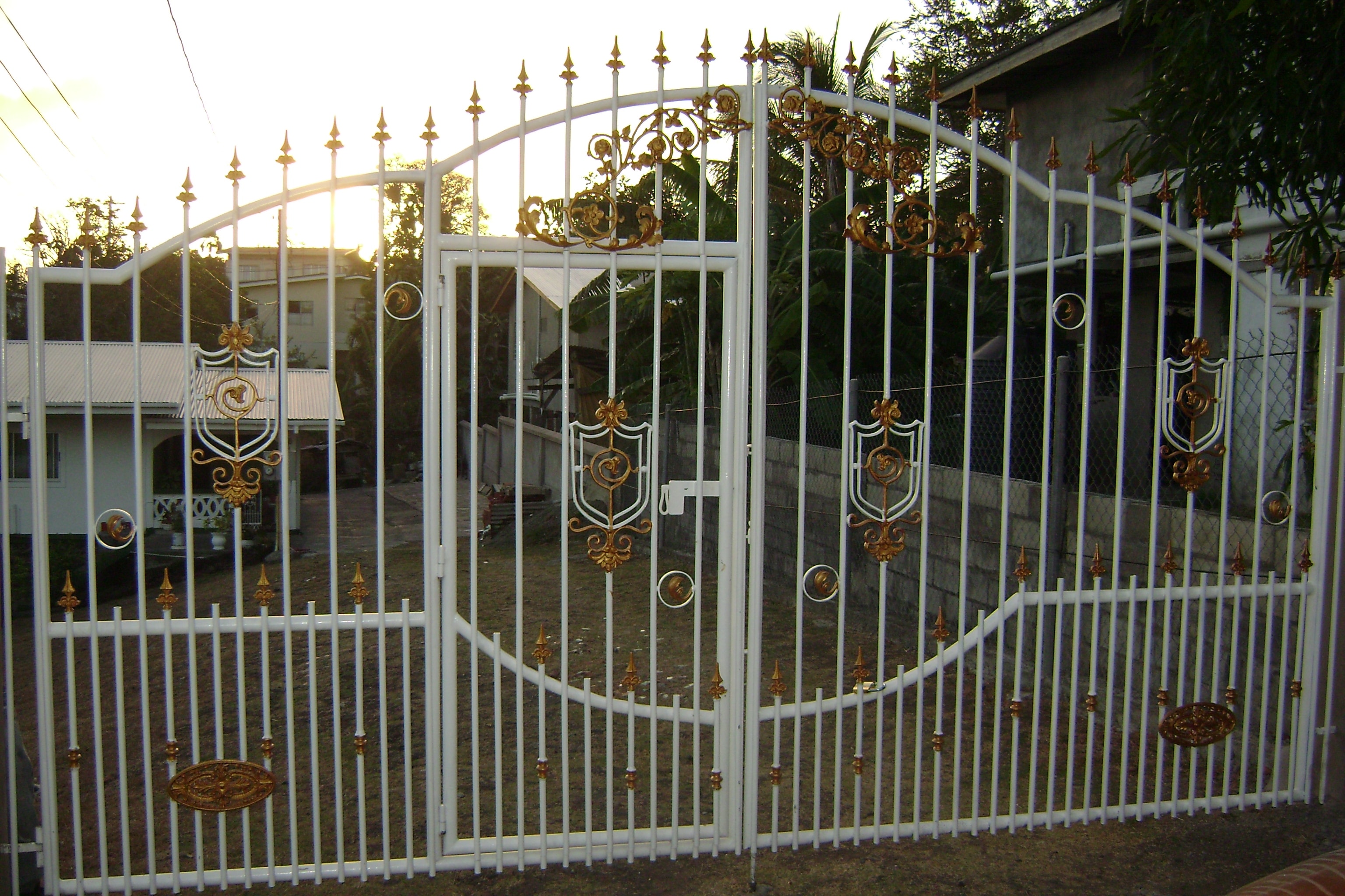 Ornate white metal gate with gold accents